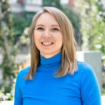Headshot of blond woman in blue shirt smiling
